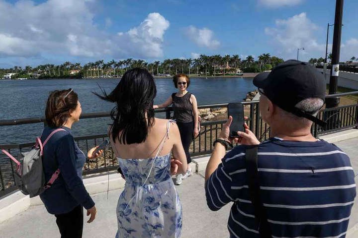 Turistas chineses, em visita a região sul da Flórida, tiram fotografia próximos à Mar-a-Lago, casa do presidente eleito dos Estados Unidos, Donald Trump — Foto: ROBERTO SCHMIDT / AFP