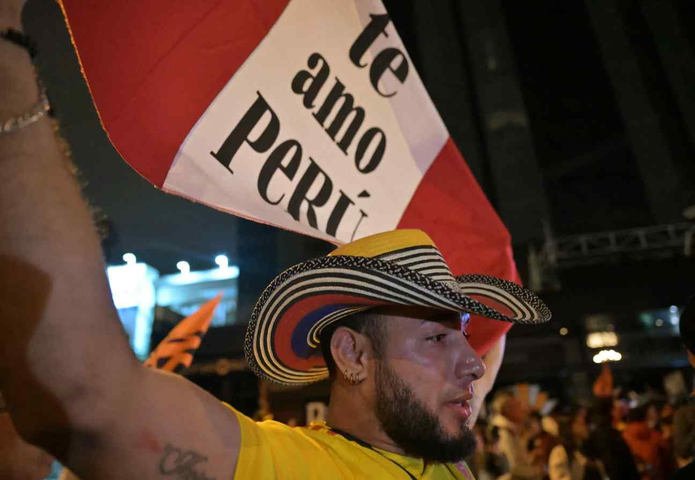Uma apoiadora da candidata à presidência do Peru, Keiko Fujimori, do partido Força Popular, exibe uma bandeira nacional com a inscrição em espanhol "Eu amo o Peru" — Foto: MARTIN BERNETTI / AFP