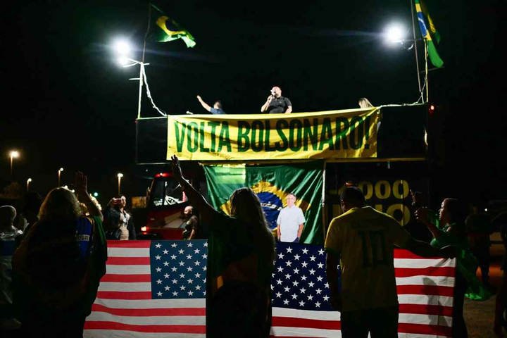 Apoiadores do ex-presidente brasileiro Jair Bolsonaro rezam em frente ao seu condomínio em Brasília, em 11 de setembro de 2025. — Foto: Pablo Porciúncula/AFP