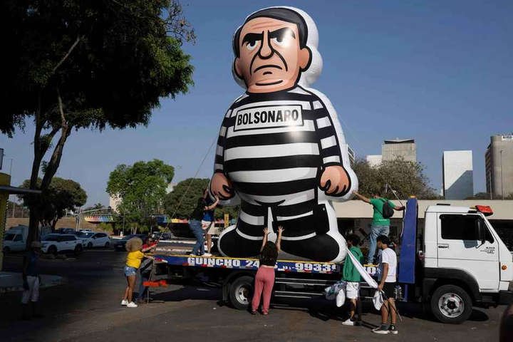 Estudantes exibem um boneco inflável gigante retratando o ex-presidente do Brasil Jair Bolsonaro vestido como prisioneiro, um dia após o Supremo Tribunal Federal tê-lo condenado a 27 anos de prisão por conspiração golpista — Foto: Pablo Porciúncula/AFP