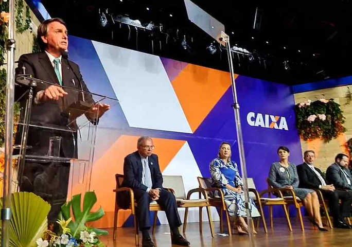 Bolsonaro discursa na posse da nova presidente da Caixa, Daniella Marques, observado por ela, o ministro Paulo Guedes, a primeira-dama, Michelle Bolsonaro, e o presidente da Câmara, Arthur Lira (PP-AL) — Foto: Reprodução