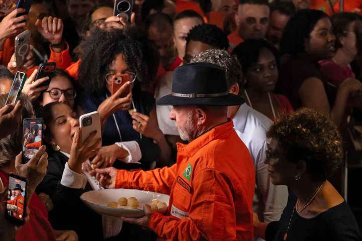 Presidente Lula distribui pão de queijo para apoiadores durante um evento na Refinaria Gabriel Passos, em Betim — Foto: Douglas MAGNO / AFP