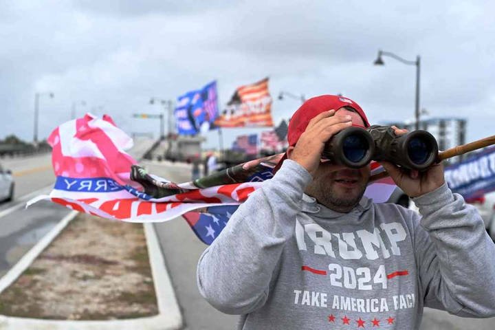 Apoiador de Trump observa o resort por binóculos — Foto: ROBERTO SCHMIDT / AFP