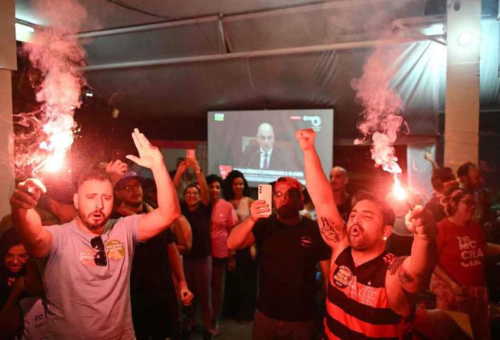 Pessoas no bar comemorando a decisão do Supremo Tribunal Federal sobre o julgamento do ex-presidente Jair Bolsonaro em Brasília, em 11 de setembro de 2025 — Foto: Evaristo Sá/AFP